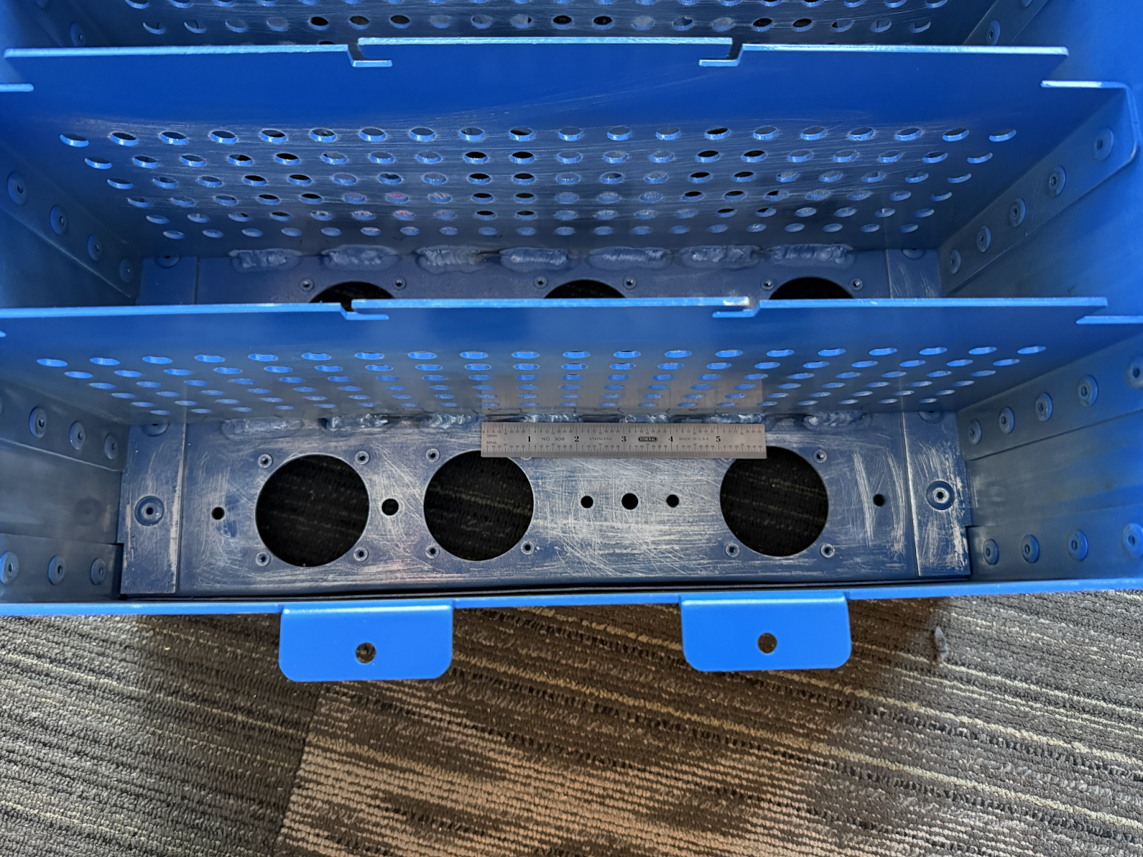 Approx. 1'' welds added along the base of each divider wall to meet SES requirements and improve structural rigidity