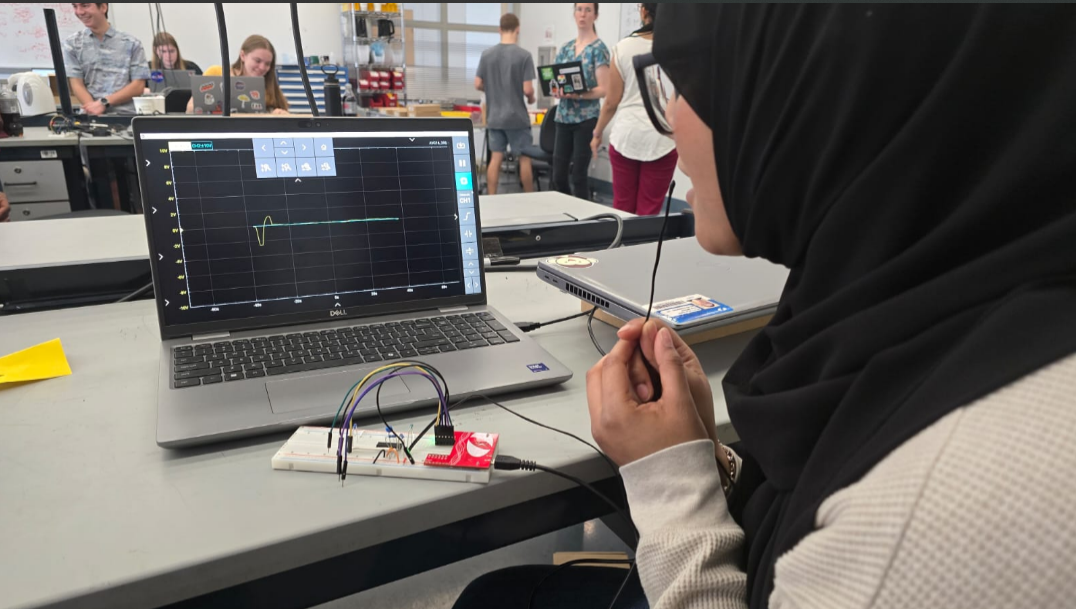 Me exhaling onto the thermistor while the circuit captures the resulting voltage signal. The waveform displayed on the laptop confirms successful real time detection and amplification of thermal fluctuations caused by breathing.